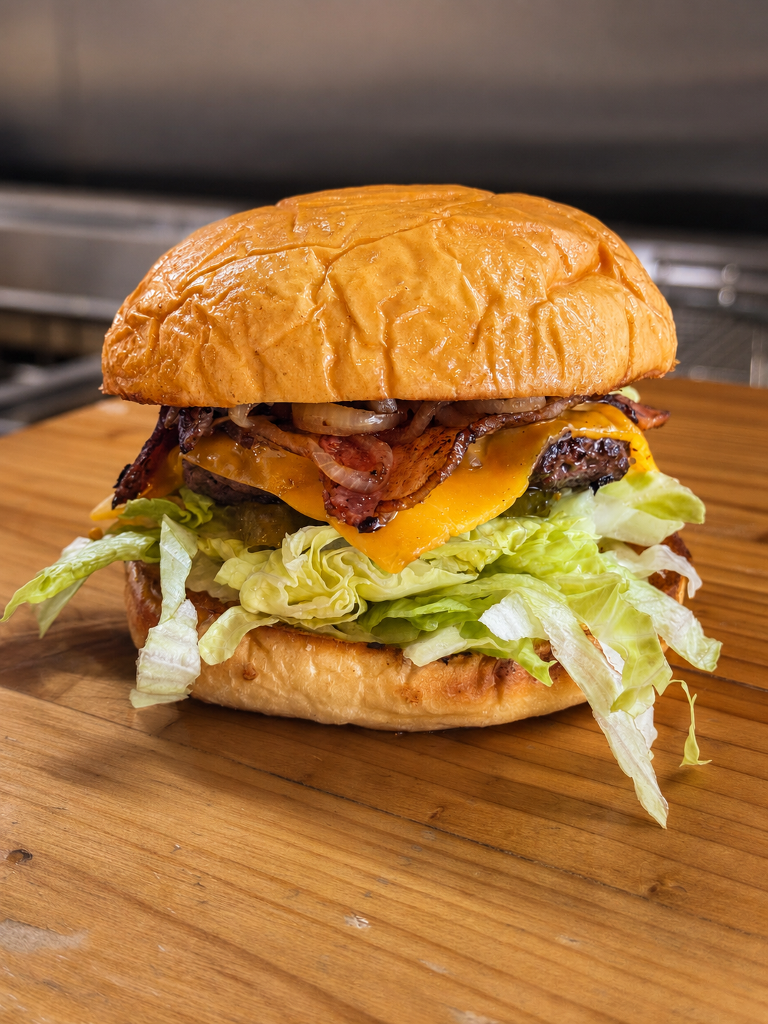 Single beef burger with cheese, bacon, grilled onions and lettuce